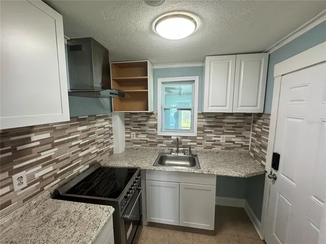 a kitchen with a sink stove and cabinets