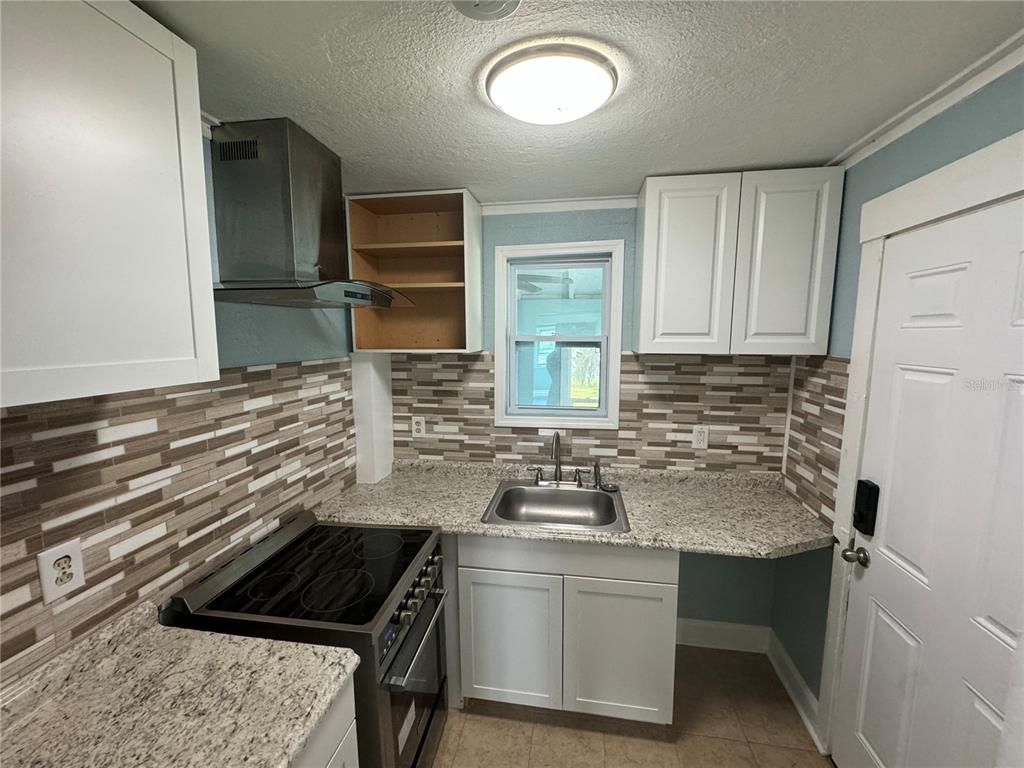 348 South Central Avenue, Unit U Umatilla, FL 32784 - Photo 7 of 13 a kitchen with a sink stove and cabinets