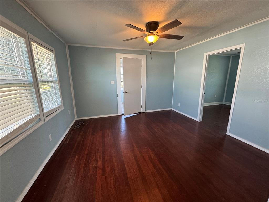 348 South Central Avenue, Unit U Umatilla, FL 32784 - Photo 10 of 13 an empty room with wooden floor and windows