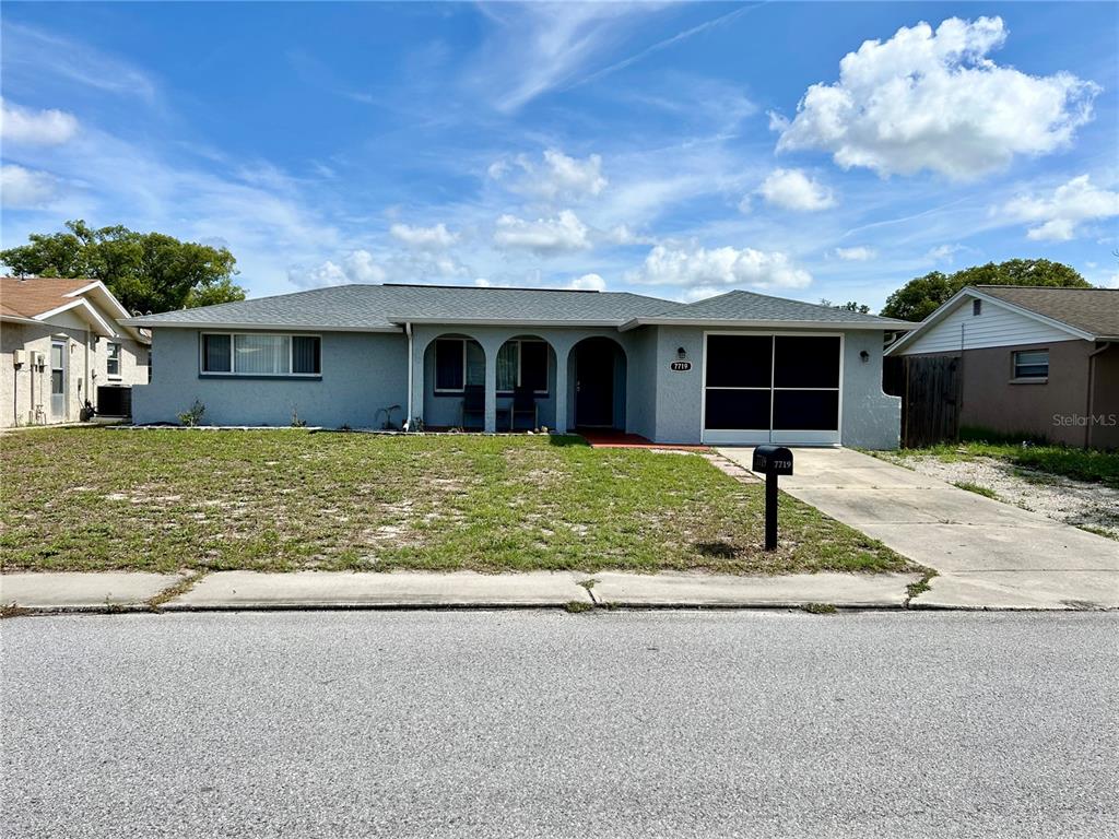 7719 Gaston Drive Port Richey, FL 34668 - Photo 1 of 1 a front view of a house with a yard and garage
