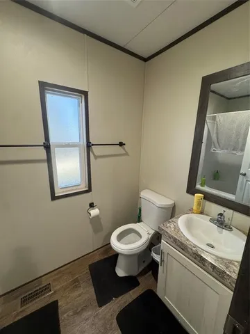 a bathroom with a granite countertop toilet and a sink