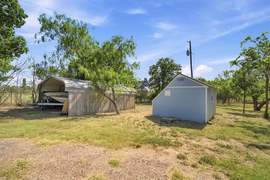 3325 Dove Creek Road Cleburne, TX 76031 - Photo 28 of 40 Detached storage shed with light blue siding and white trim, featuring a gable roof and a small window
