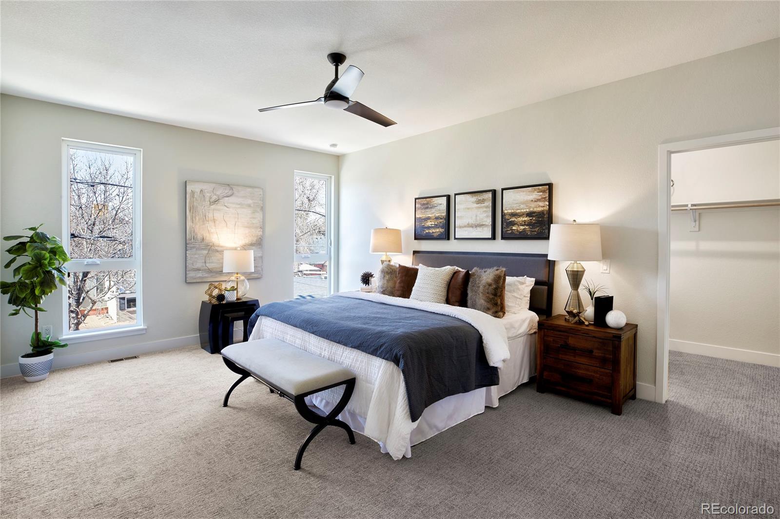 2951 East Evans Avenue Denver, CO 80210 - Photo 11 of 39 a spacious bedroom with a bed a couch and potted plant on the dresser