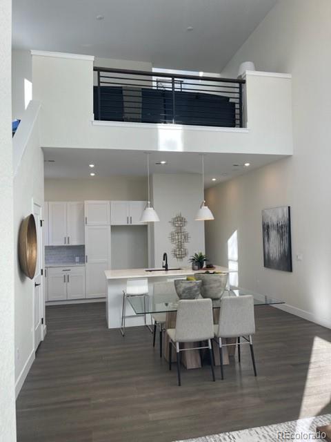 2951 East Evans Avenue Denver, CO 80210 - Photo 32 of 39 a kitchen with a dining table chairs and stainless steel appliances