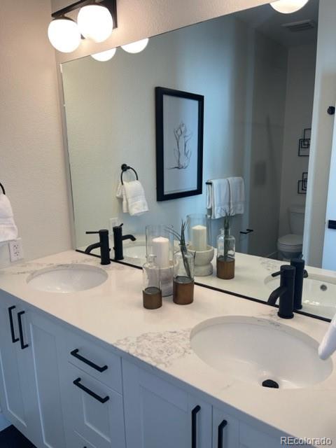 2951 East Evans Avenue Denver, CO 80210 - Photo 37 of 39 a bathroom with a sink and a mirror