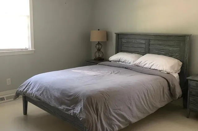 a bed sitting in a bedroom next to a window