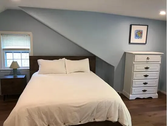 a bedroom with a bed and a painting on the wall