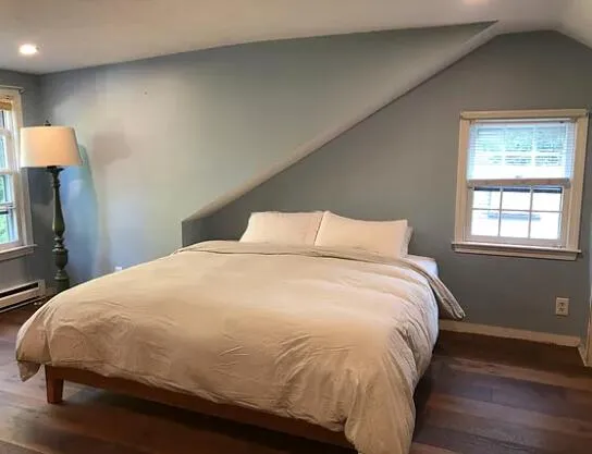 a large bed sitting in a bedroom next to a window