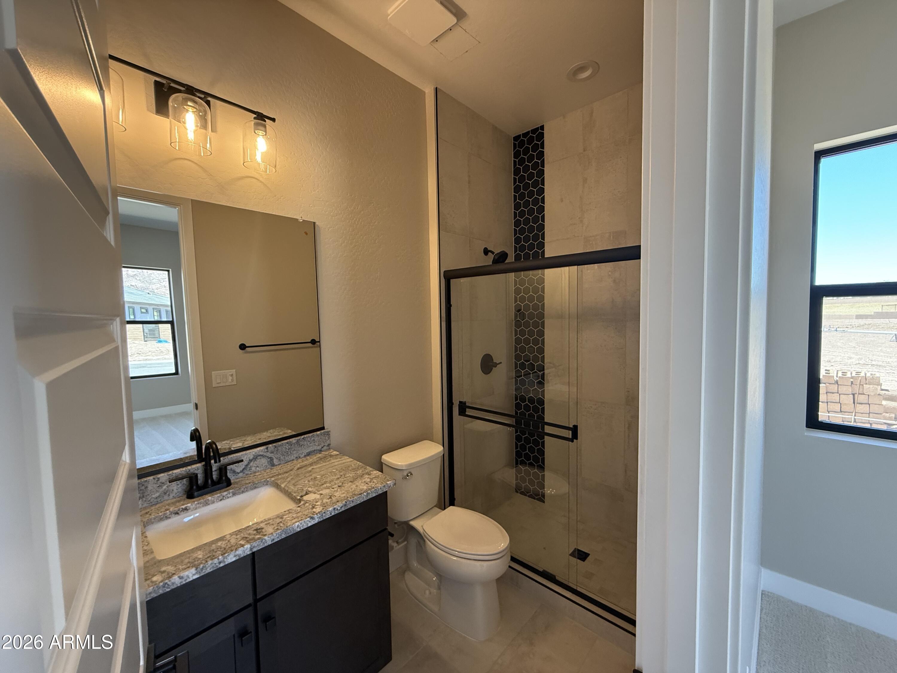 11139 East Rio Bravo Road Gold Canyon, AZ 85118 - Photo 11 of 14 a bathroom with a granite countertop sink toilet mirror and shower