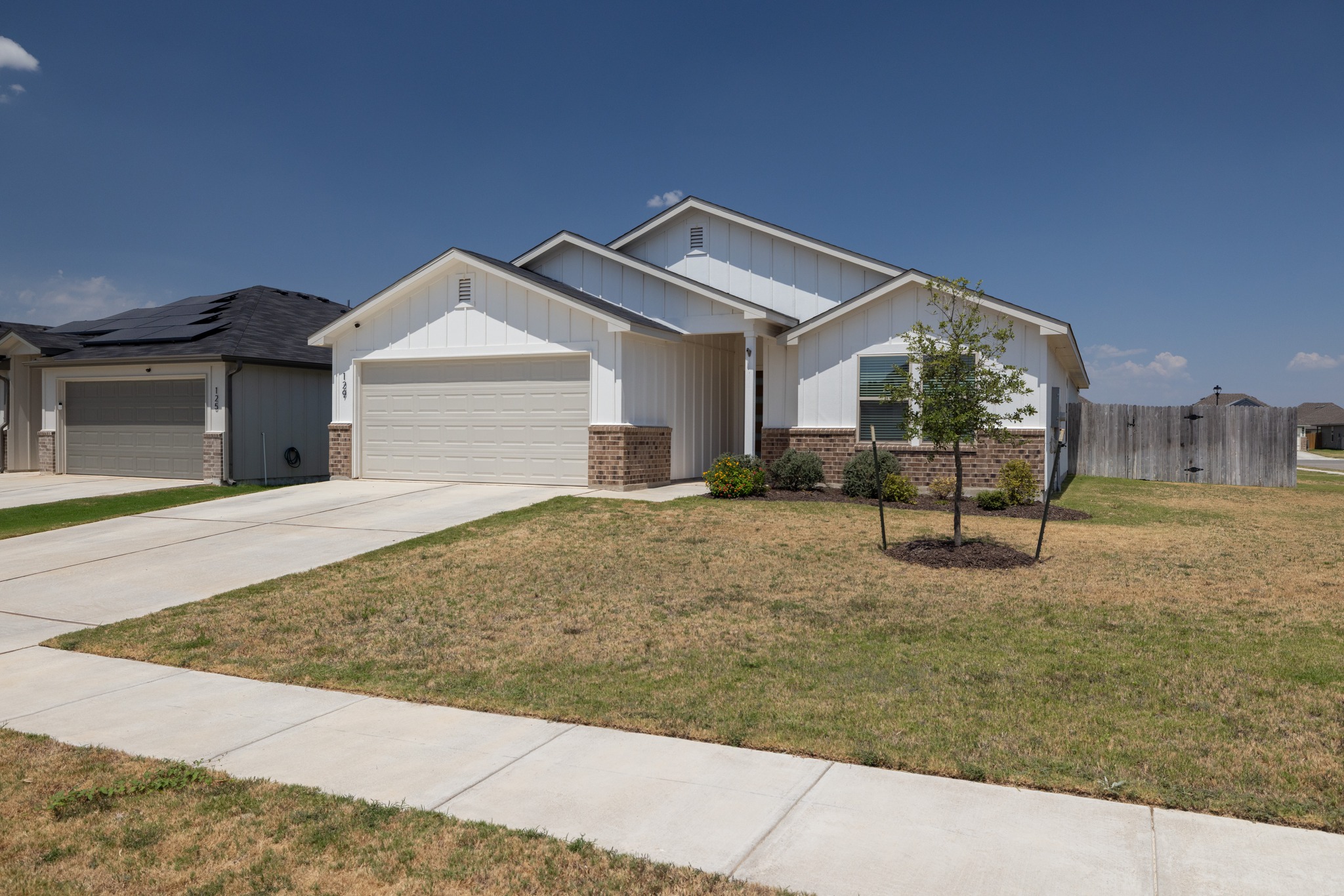 129 Maybelline Road Jarrell, TX 76537 - Photo 3 of 28 Clean lines and a manicured lawn define this modern single-story elevation.