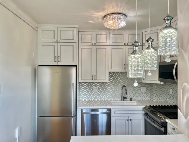 a kitchen with a refrigerator a sink and cabinets