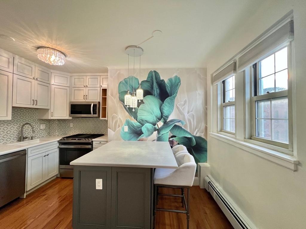 1454 Beacon Street, Unit 744 Brookline, MA 02446 - Photo 5 of 18 a kitchen with a stove a sink and a microwave