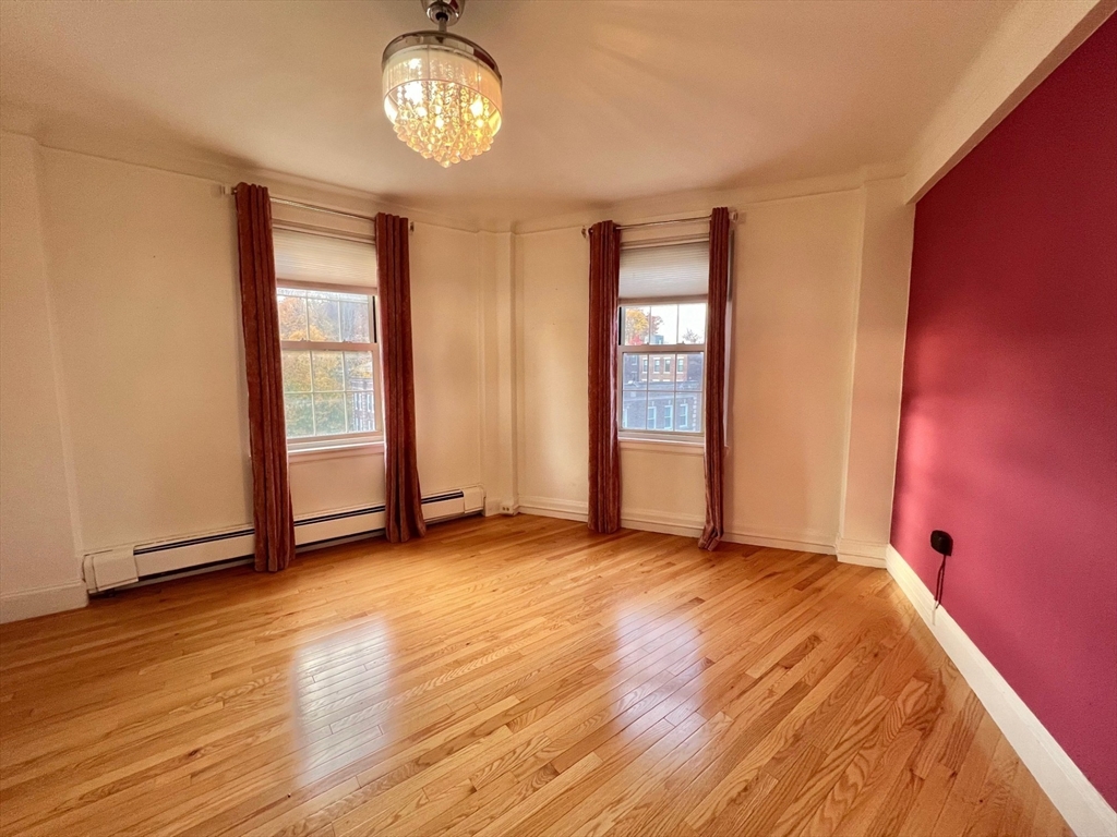 1454 Beacon Street, Unit 744 Brookline, MA 02446 - Photo 9 of 18 an empty room with wooden floor and windows