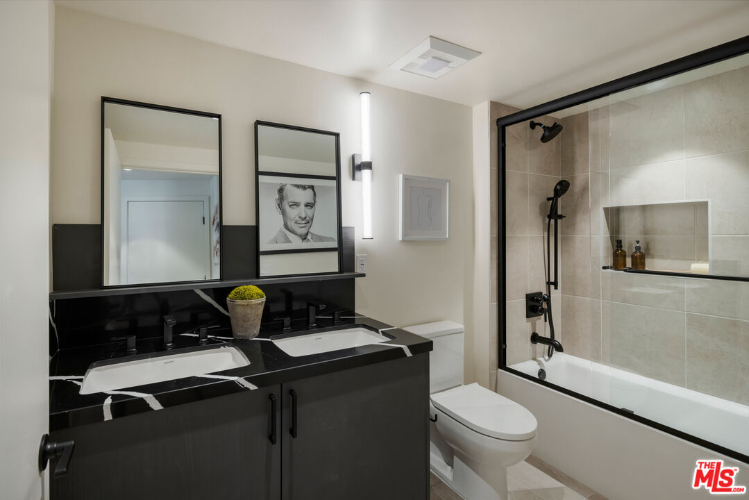 1110 South Spaulding Avenue, Unit 305 Los Angeles, CA 90019 - Photo 6 of 13 a bathroom with a toilet a sink and mirror