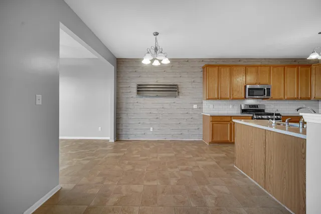 a view of a kitchen with a sink wooden cabinets and a window