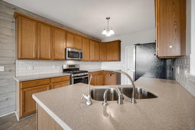 a kitchen with stainless steel appliances granite countertop a sink a stove and a microwave