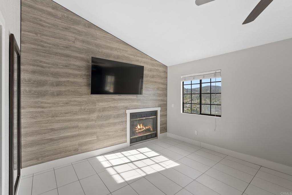 9309 Hillside Drive Spring Valley, CA 91977 - Photo 36 of 64 a living room with a fireplace a flat screen tv and windows