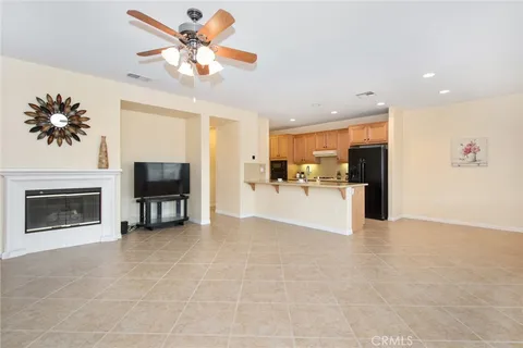 a view of an empty room with chandelier fan and a bathroom