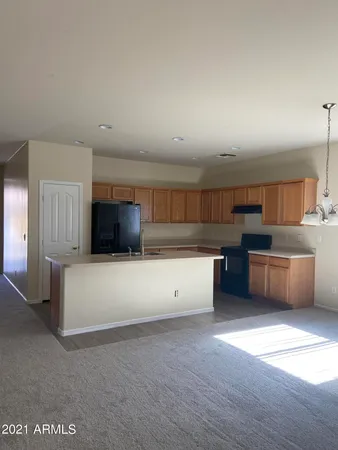 a large white kitchen with a large counter top and stainless steel appliances