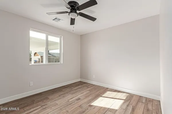 an empty room with a window and wooden floor