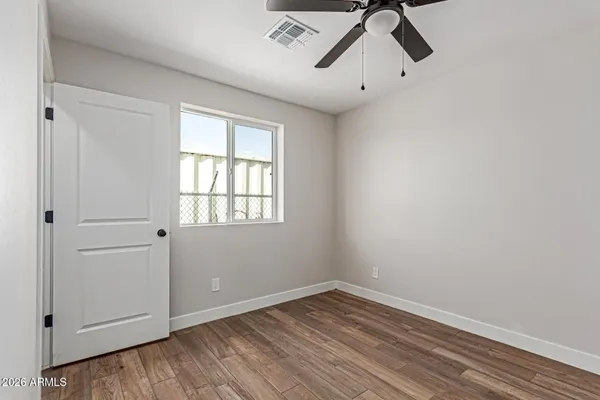 a view of empty room with wooden floor