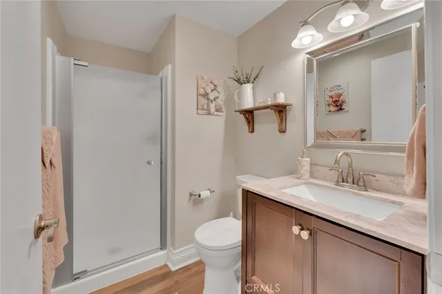 a bathroom with a granite countertop sink toilet and shower