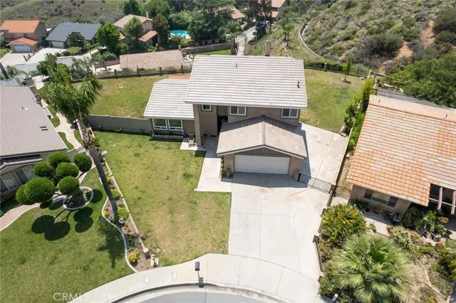 an aerial view of a house with swimming pool and large trees