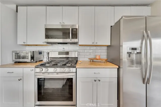 a kitchen with stainless steel appliances granite countertop a stove a refrigerator and a microwave