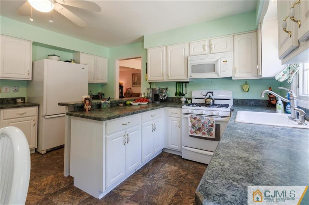 81 Spring Hill Road Old Bridge, NJ 07747 - Photo 22 of 40 a kitchen with stainless steel appliances a sink a stove a refrigerator cabinets and a counter top space