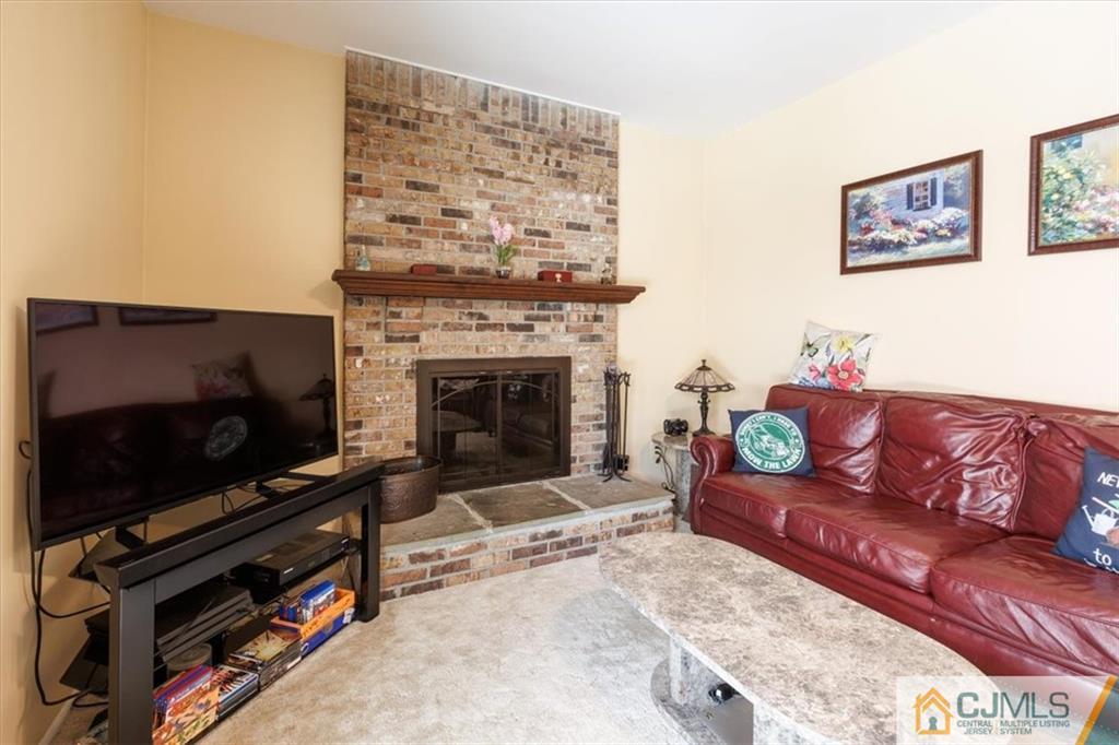 81 Spring Hill Road Old Bridge, NJ 07747 - Photo 24 of 40 a living room with furniture a flat screen tv and a fireplace