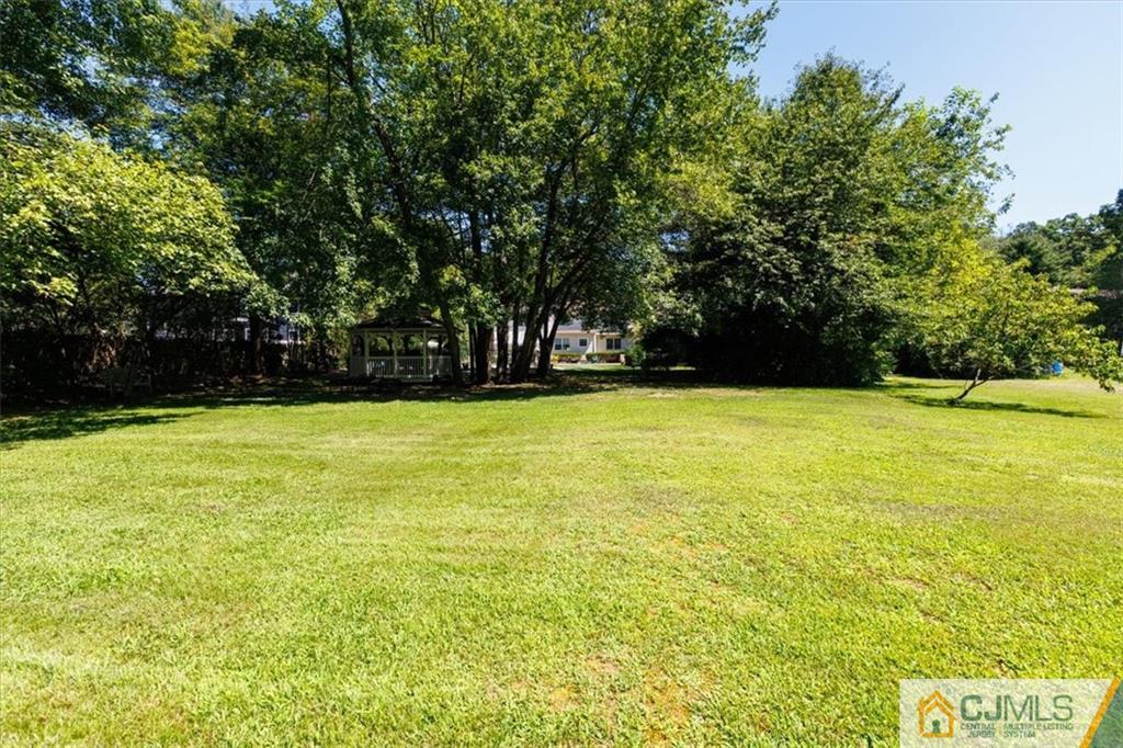 81 Spring Hill Road Old Bridge, NJ 07747 - Photo 9 of 40 a view of a swimming pool and trees in the background