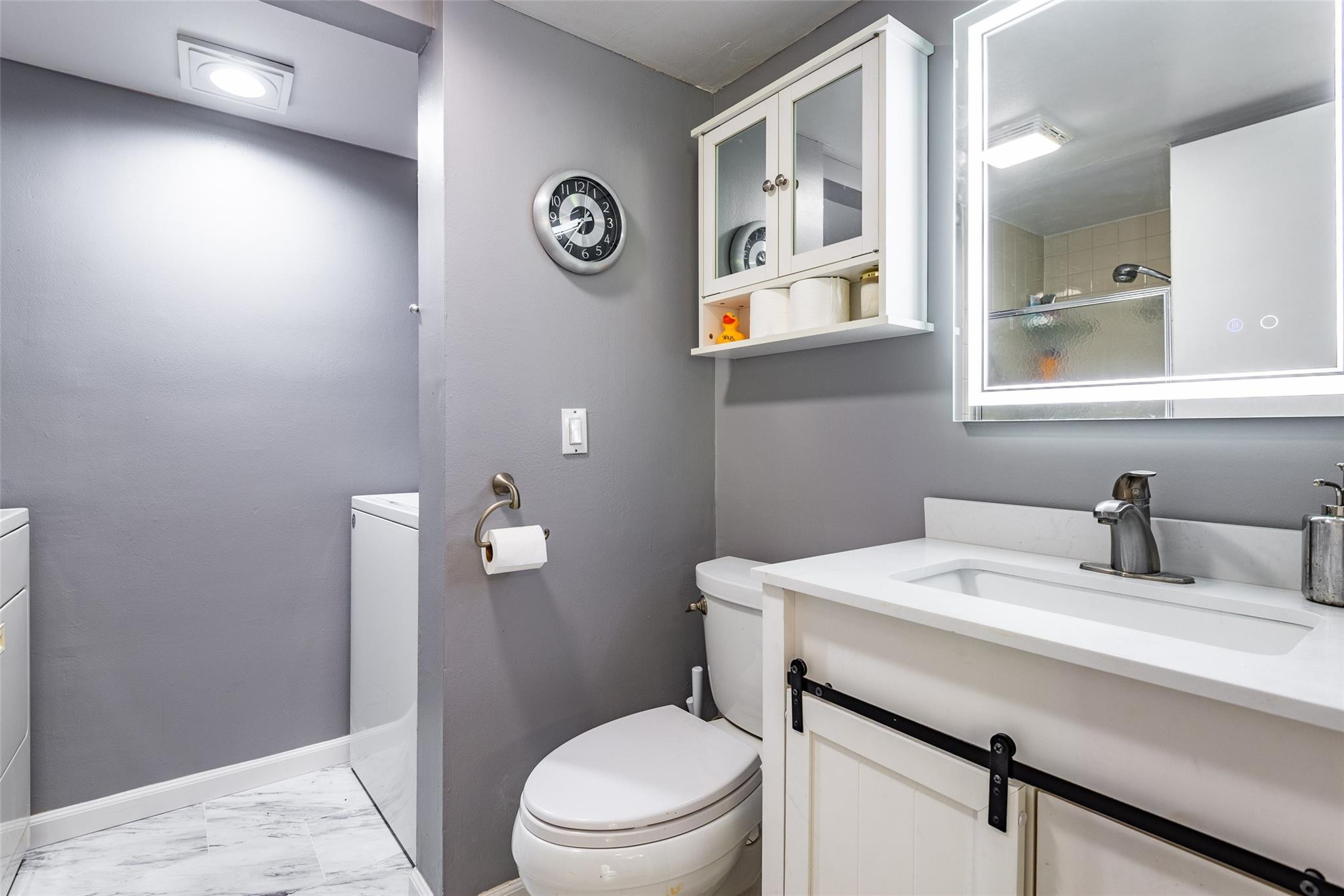 22208 Boca Rancho Drive, Unit D Boca Raton, FL 33428 - Photo 12 of 34 a bathroom with a sink a toilet and mirror