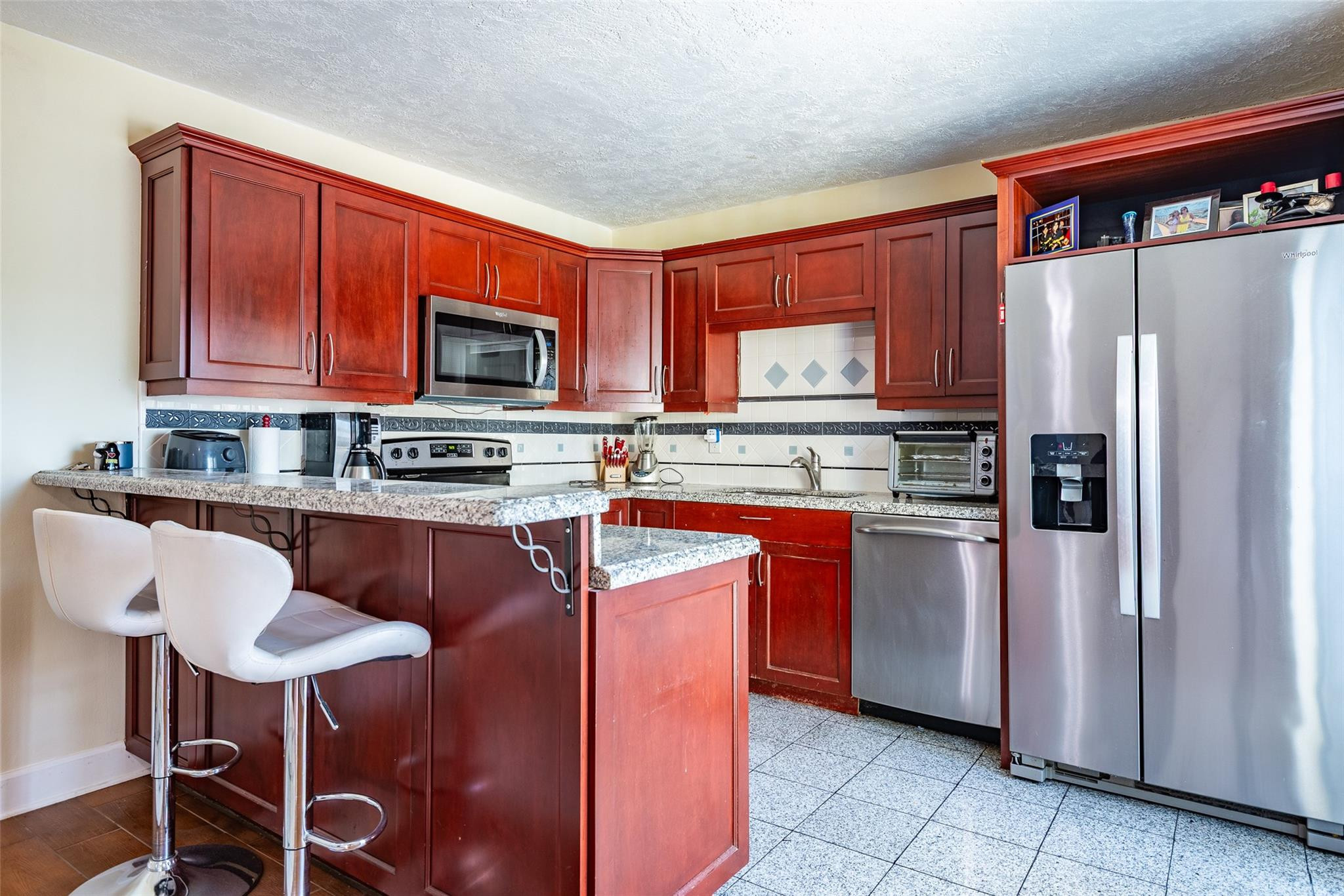 22208 Boca Rancho Drive, Unit D Boca Raton, FL 33428 - Photo 8 of 34 a kitchen with stainless steel appliances granite countertop a stove refrigerator and a microwave