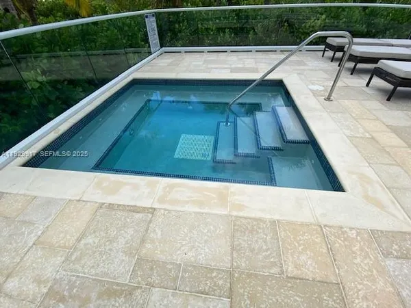 a view of a swimming pool with outdoor seating and a tub