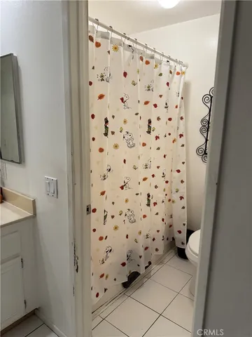 a living room with furniture and a dining table with kitchen appliances