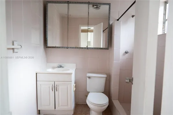 a bathroom with a toilet a sink and a mirror