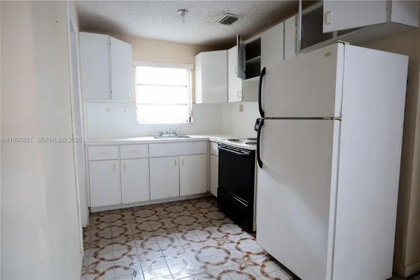 a kitchen with sink refrigerator and cabinets