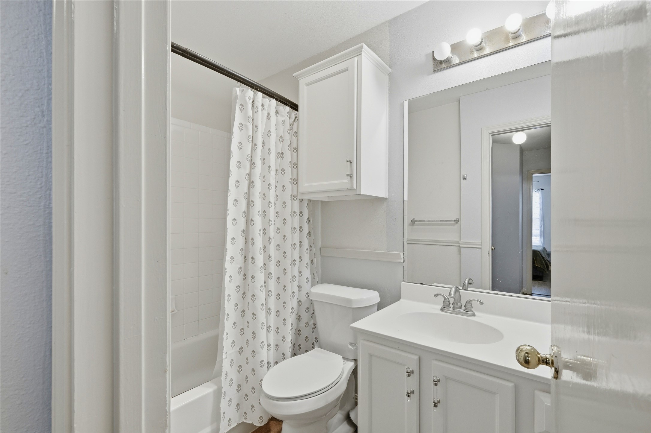 310 Raintree Drive Georgetown, TX 78626 - Photo 10 of 12 A compact, efficient bathroom featuring a pristine white vanity and shower-over-tub combination.
