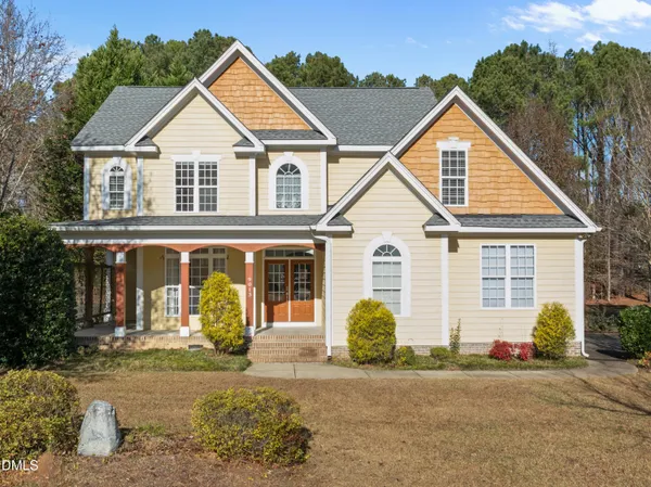 a view of a white house with large windows next to a road