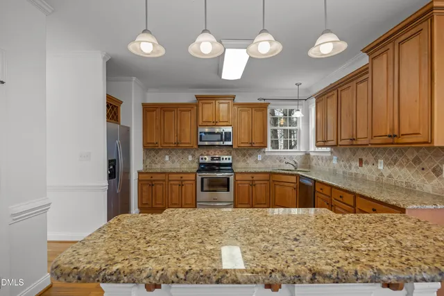 a kitchen with granite countertop a stove cabinets and wooden floor