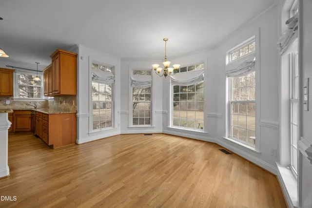 a view of empty room with wooden floor and fireplace