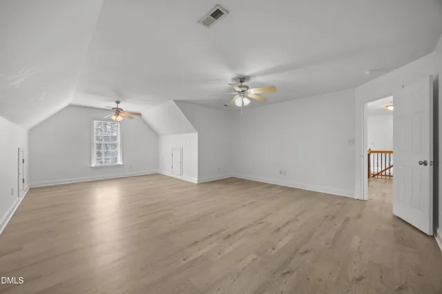 en empty room with windows and ceiling fan