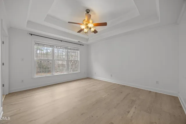 an empty room with closet and a chandelier fan