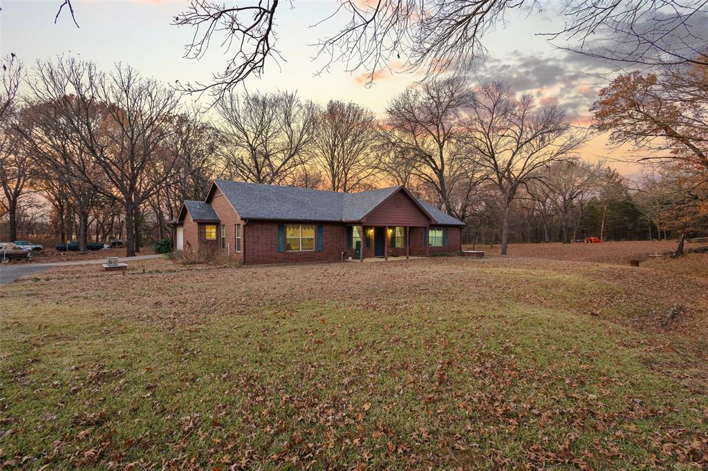 80 Campbell Road Sadler, TX 76264 - Photo 13 of 29 Ranch-style house with a yard, brick siding, view of scattered trees, and a porch
