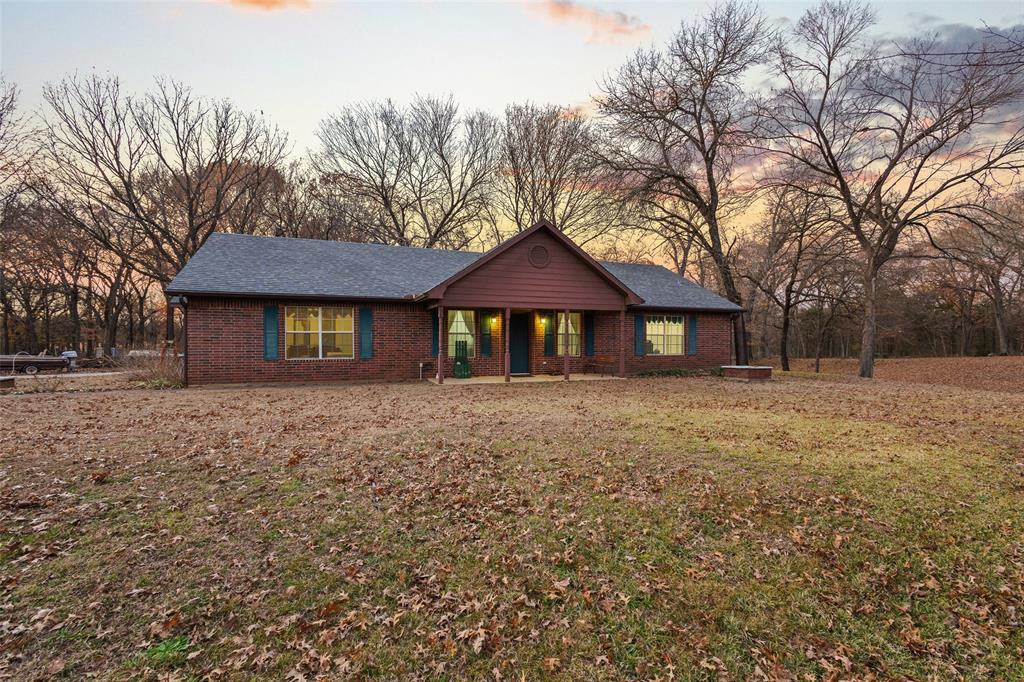 80 Campbell Road Sadler, TX 76264 - Photo 20 of 29 Single story home featuring brick construction, a yard, covered porch, and view of mature trees