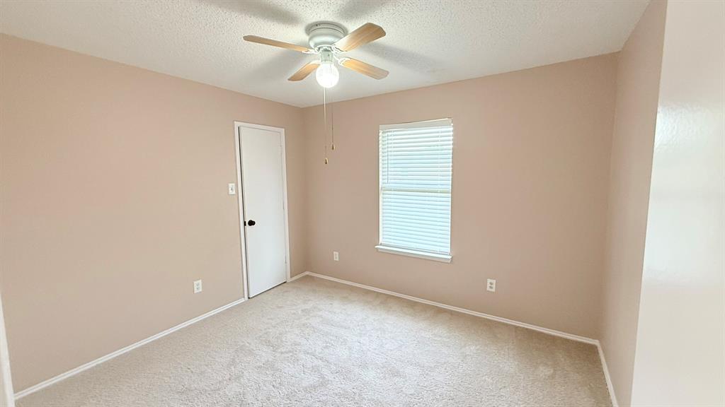 12259 Rim Rock Road Dallas, TX 75253 - Photo 16 of 17 Carpeted empty room with a textured ceiling and ceiling fan