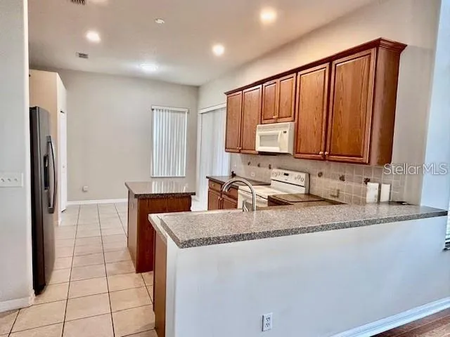 a kitchen with stainless steel appliances granite countertop a sink refrigerator and microwave