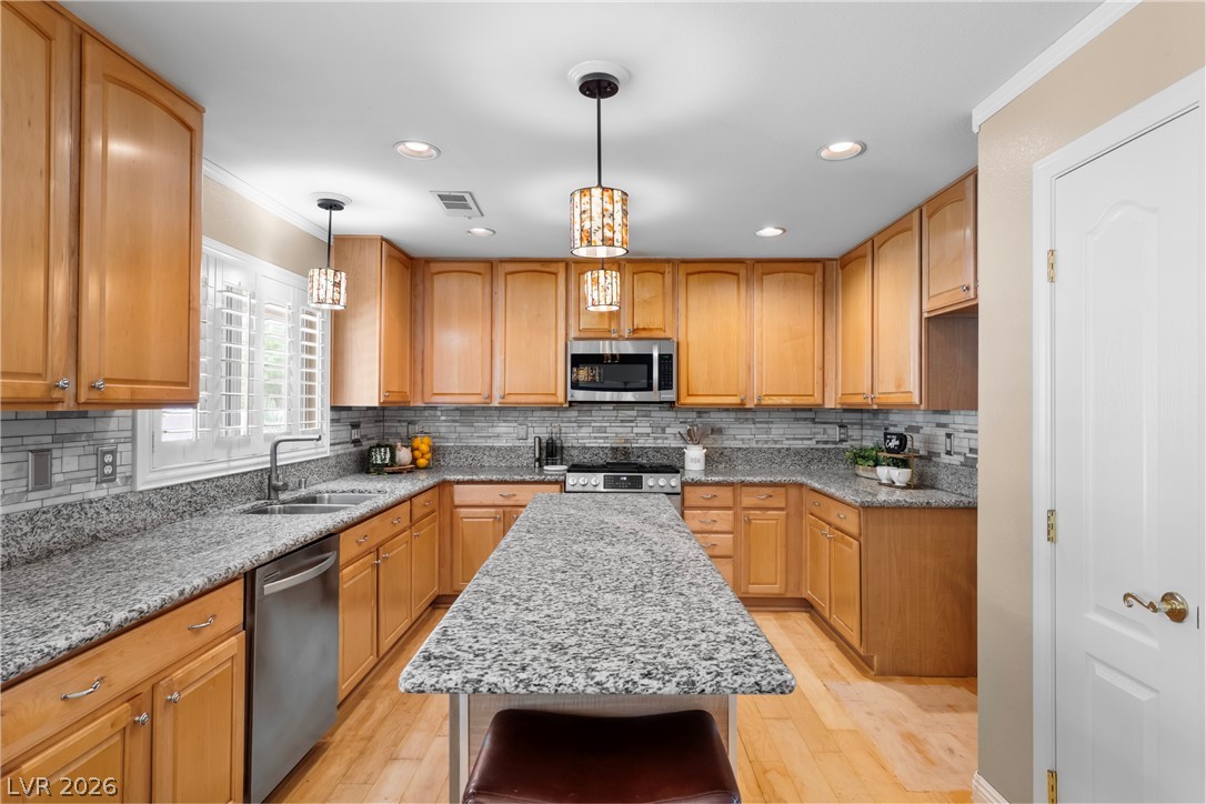 708 Vortex Avenue Henderson, NV 89002 - Photo 13 of 71 Culinary haven with granite counters and gleaming stainless steel appliances.