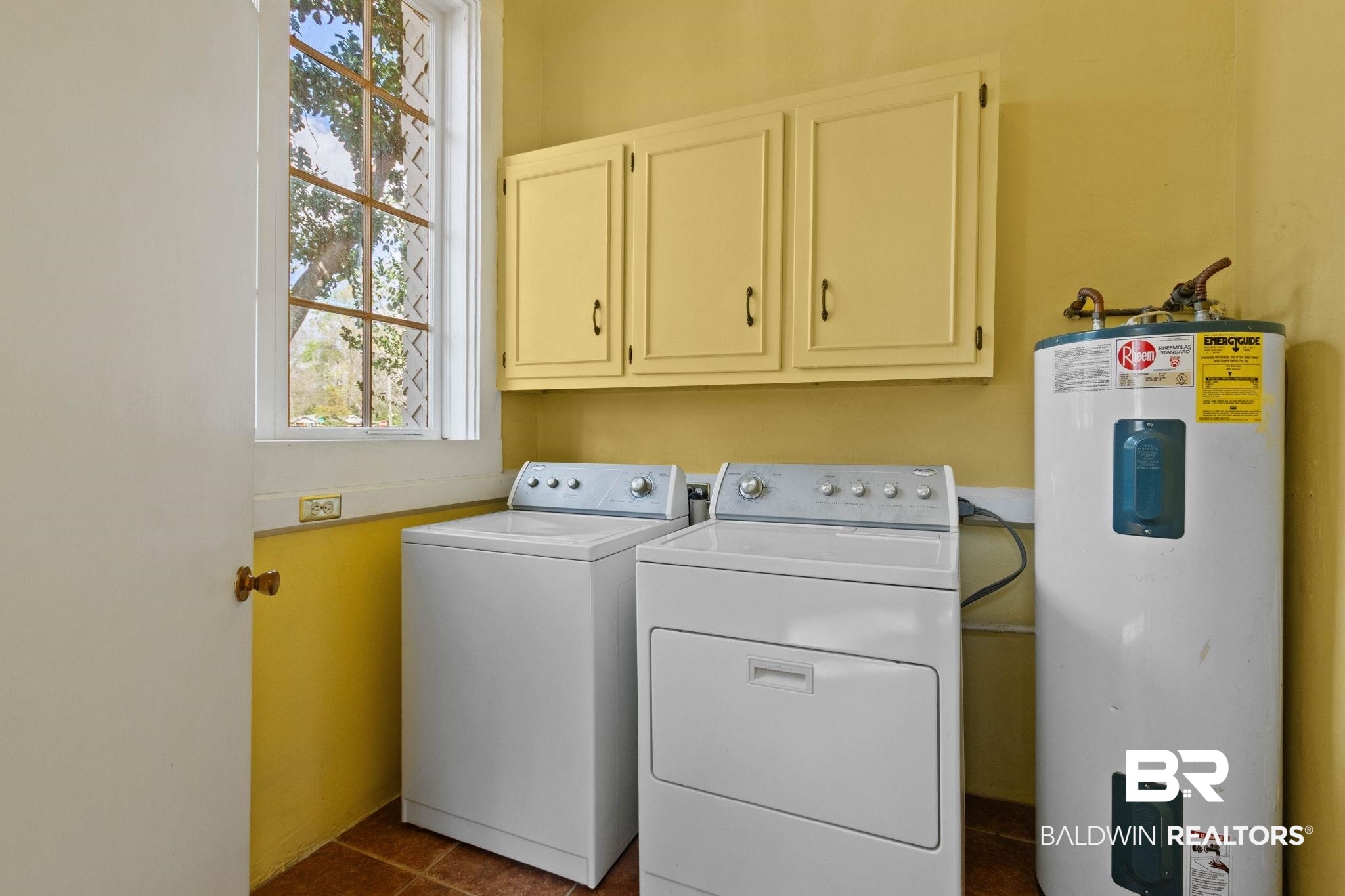 1701 Sowell Road Brewton, AL 36426 - Photo 72 of 83 Laundry area with water heater, cabinet space, healthy amount of natural light, and washer and dryer
