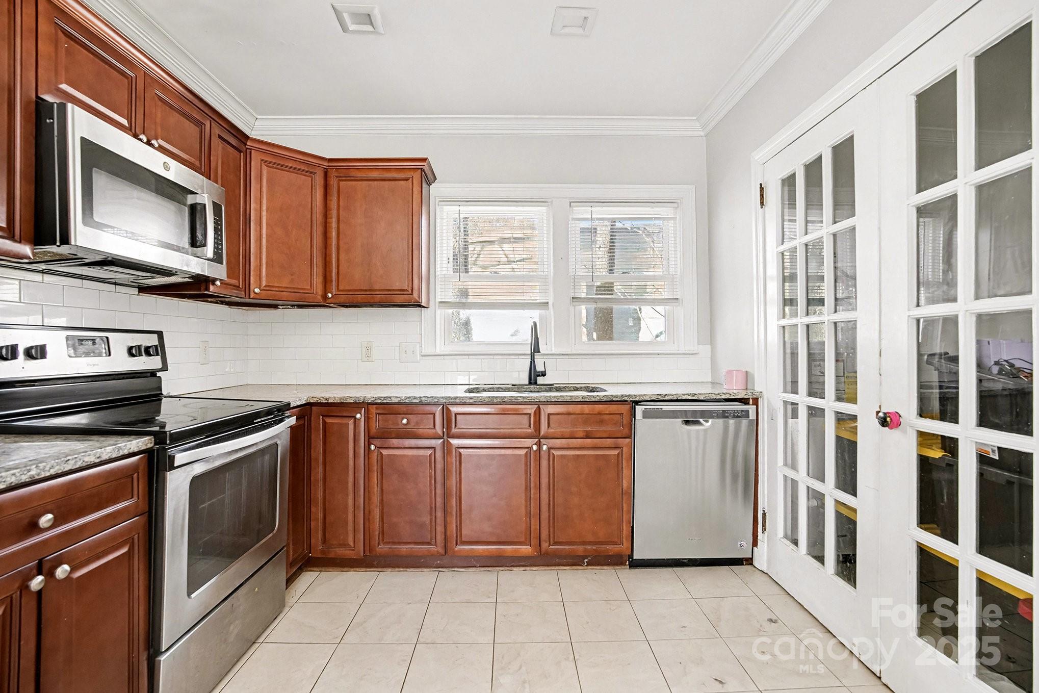 406 South Catawba Street Lancaster, SC 29720 - Photo 22 of 35 a kitchen with stainless steel appliances granite countertop a stove top oven a sink dishwasher and granite countertops